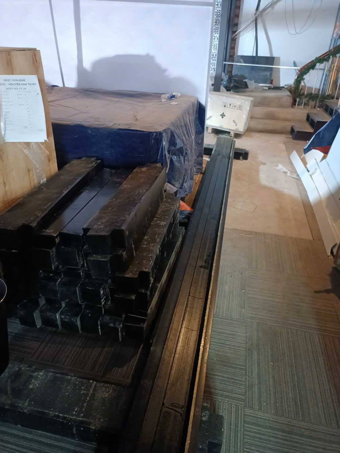 Thanh sắt hộp chữ nhật màu đen xếp chồng trong kho chuẩn bị thi công lắp đặt